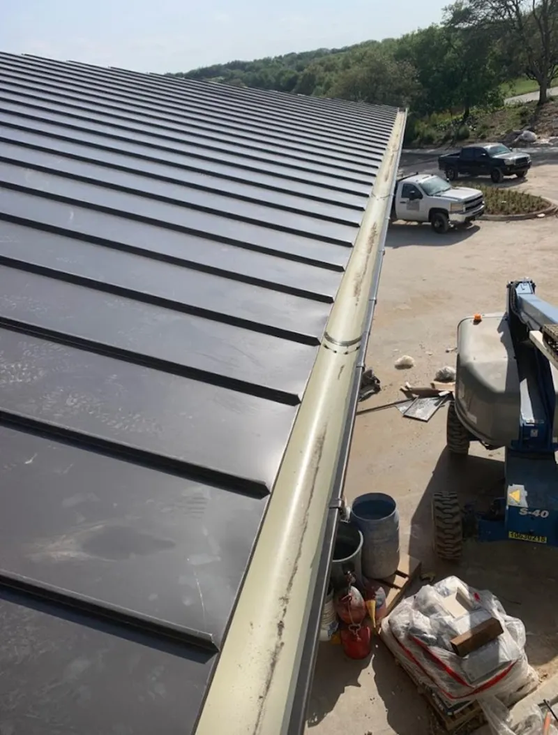 Standing seam panel and gutter detail on a metal roofing jobsite in Wildewood